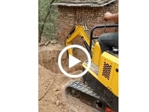 小型挖掘機在農村牆邊挖坑